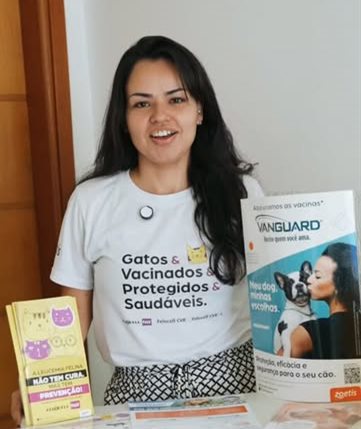 Atendente mostrando material sobre vacinação de gatos